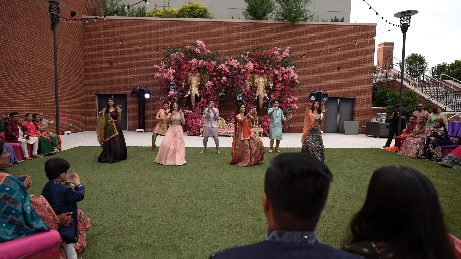 Family and friends performing together at an outdoor wedding